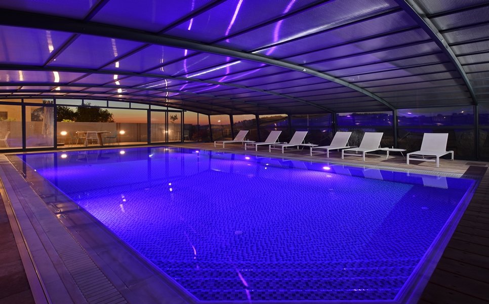 The covered pool in the evening, with sun loungers